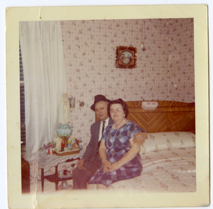 Nuno Andrade and Luiza Melo Andrade sitting on bed