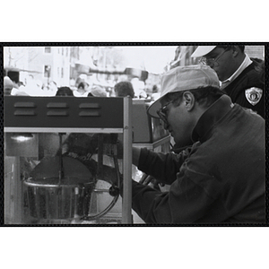 A staff member pouring popcorn into the popcorn machine at the Boys and Girls Clubs of Boston 100th Anniversary Celebration Street Fair