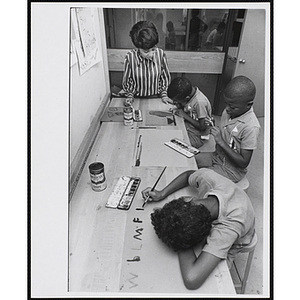 An art instructor and three boys working on drawings at the Boys' Clubs of Boston