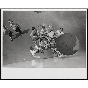 Boys watch a ball bounce between the rim and backboard during an outdoor pickup basketball game