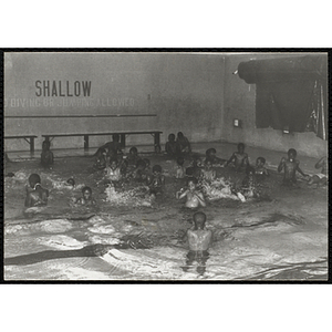 A group of boys swim in a natorium pool