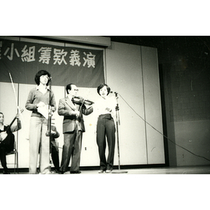 Two women sing with an accompanying band on stage at the Chinatown Task Force Fundraiser