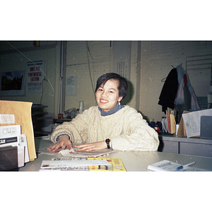 Member of Chinese Progressive Association at an office desk