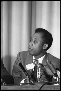 James Baldwin, seated on a panel at the Youth, Non-Violence, and Social Change conference, Howard University