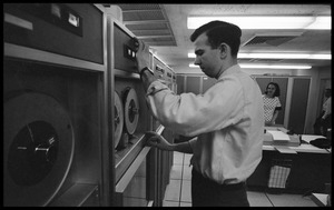 Man mounting a tape on a Honeywell Model 400 mainframe computer