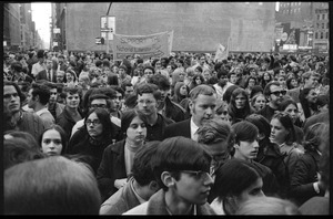 Protesters crowd the streets near Bryant Park for the Vietnam Moratorium demonstrations, sign reads 'Support the National Liberation Front'