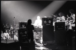 Santana concert at the Springfield Civic Center: view of band and audience from behind bank of audio equipment