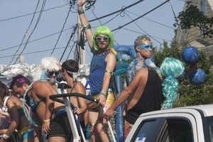 Parade marchers waving from atop a float : Provincetown Carnival parade