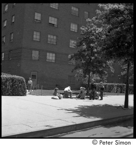 Children playing on the sidewalk in front of a Riverdale apartment building