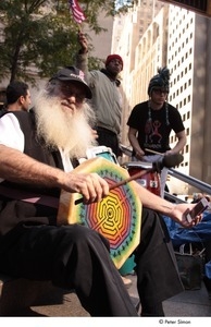 Occupy Wall Street: demonstrator with a long, white beard playing a frame drum in a drum circle
