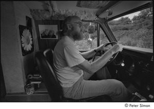 Ram Dass in his van: Ram Dass in the driver's seat with a picture of of Neem Karoli Baba behind him