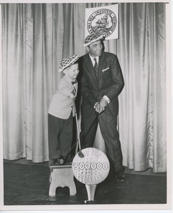 Ed Furgol and Billy Bruckner posing with clubs and golf hats at a fundraiser