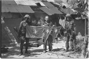 U.S. soldiers with captured Vietcong flag; Hau Nghia.