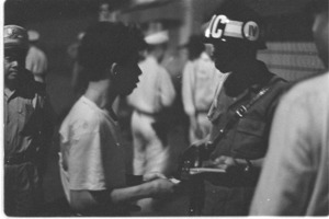 Policemen checking identity papers of dwellers in slum area of Vinh Hoi.