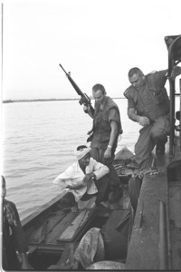 Crew of PBR checking the cargo of a Vietnamese peasant's boat; Dong Nai River.