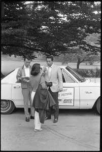 Visitors standing next to a courtesy car at Newport Jazz Festival