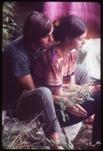 Young couple huddled on the grass, Woodstock Festival