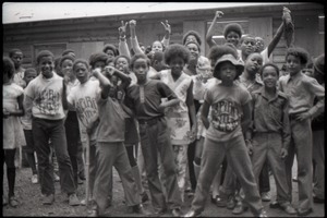 Inner City Round Table of Youth campers:group of African American campers, some wearing Spirit in Flesh t-shirts, standing outside summer camp cabins
