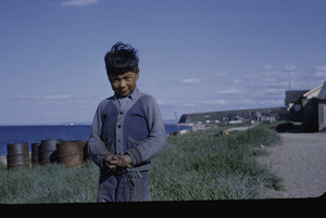 Young boy in front of his house