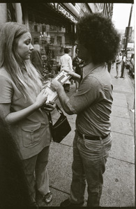 Abbie Hoffman walking in Harvard Square, talking with young woman (Church of the Final Judgment) handing out literature on the Second Coming