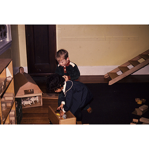 Young children sitting on the floor playing with toys