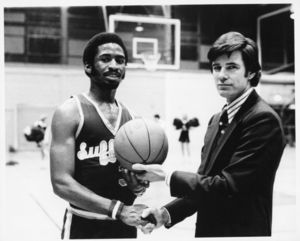 Suffolk University Athletics Director James E. Nelson (1978-2013) and basketball player Donovan Little celebrate Little's reaching 2000 points, 1979