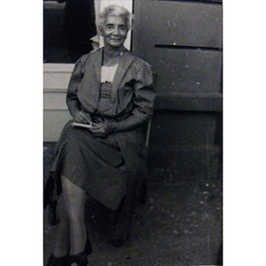 An African American woman sitting outside of a house