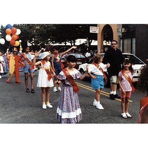Young candidates for the position of Queen of Festival Betances wave to their fans as they march in the parade.