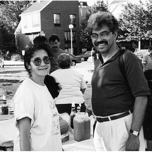 Clara Garcia and Carlos Luna standing by a food table set up outside in the Plaza.