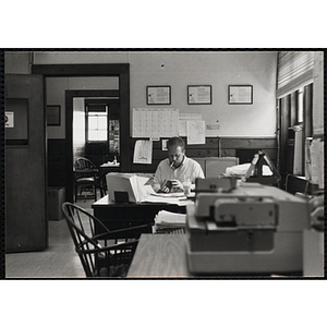 A male staff member seated at his desk in a office