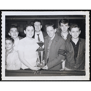 A man and six boys pose with their trophy at the Boys' Clubs of America Pocket Billiards Tournament