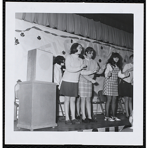 A group of teenage girls dance on a stage at a Boys' Club of Boston St. Patrick's Day inaugural ball and exercises event