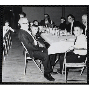 Men and boys pose for a shot at a table during a Dad's Club banquet