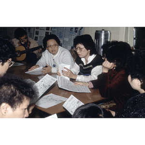 Members of the Chinese Progressive Association gather around a table for a meeting