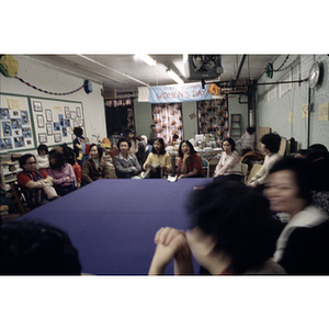 Seated guests talking at an International Women's Day event