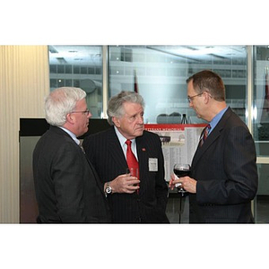 Three men converse at the Veterans Memorial dinner