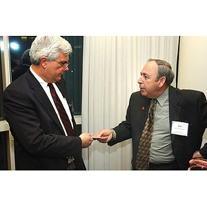 Two guests exchange a card at The National Council Dinner