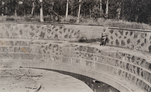 View of a soldier standing in a large stone and concrete circular German gun emplacement