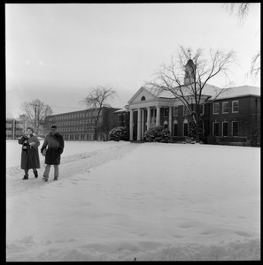 Students walking out of Goodell Library on a snowy day, with Bartlett Hall in the background