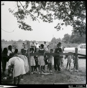 Group of African American children standing by a fence