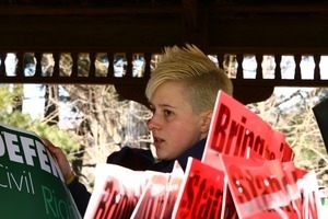 Protestor before the march with sign reading 'Defend civil rights': rally and march against the Iraq War