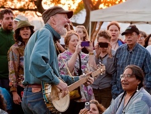 Pete Seeger playing an impromptu song with his banjo at sunset during the Clearwater Festival