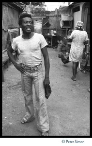 Jimmy Cliff standing in a dirt alleyway near his old home on Spanish Town Road