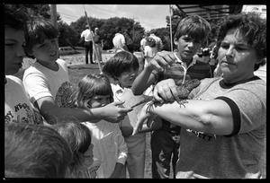 Marie Craig shows a group of youngsters the pet iguana