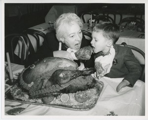 Young client eating turkey leg with unidentified woman