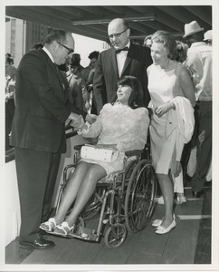 Woman in wheelchair shakes hands with man