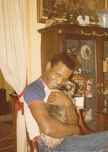 A Photograph of Marsha P. Johnson Hugging a Dog in Her Lap