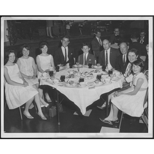 Adults and children seated around a table