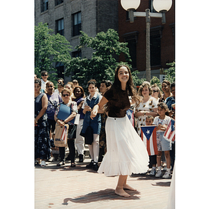 A woman dances barefoot for an audience at City Hall Plaza