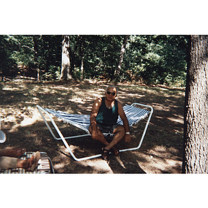 A man sits on a hammock during an outdoor picnic event